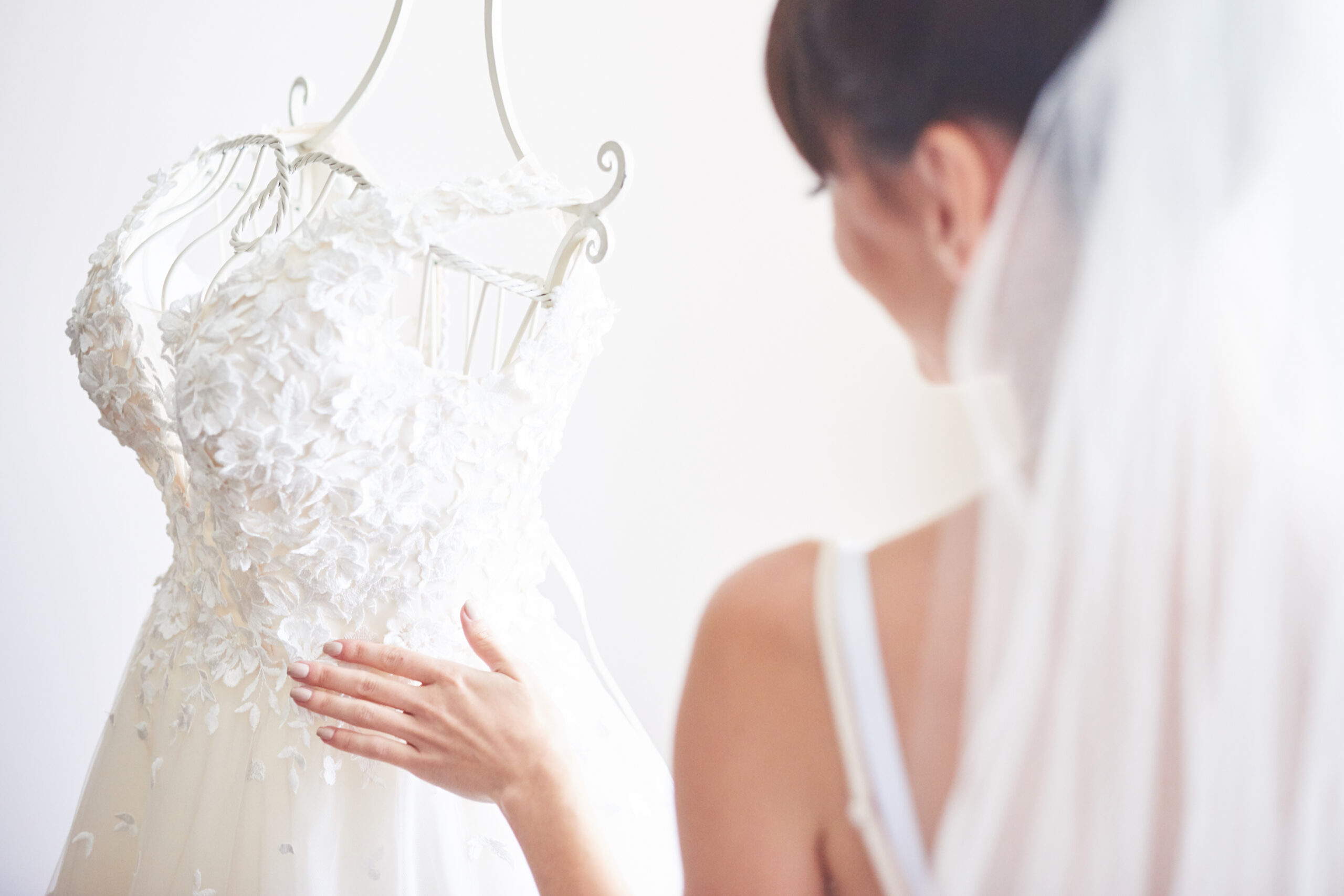 Elegant bride puts a wedding gown in her room